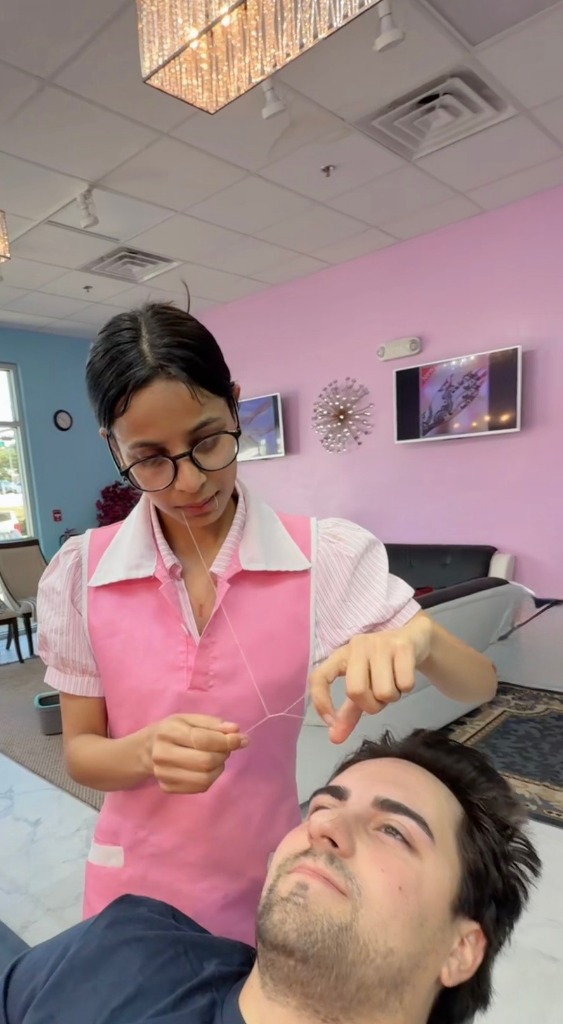 Professional threading technician at On Point Threading performing precision eyebrow shaping